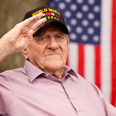 Veteran saluting in front of an American flag