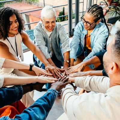 Group of people putting their hands in a circle
