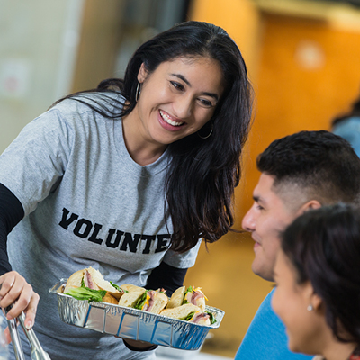 Woman wearing a gray shirt and serving food