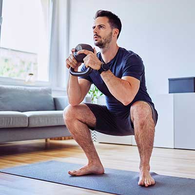 man doing squats in his house 